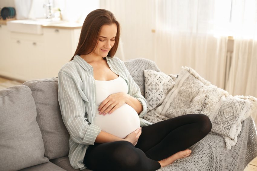 várandós nő nézi a hasát