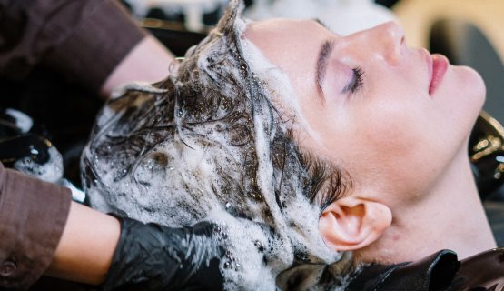 Egy fodrász egy nő haját mossa