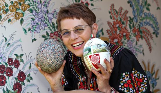 Zsigóné Kati tojásfestő művész, kezében  a Világunk tojása és a Beszélő Tojás