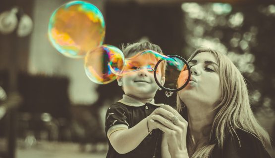 nő kisfiúval színes buborékokat fúj