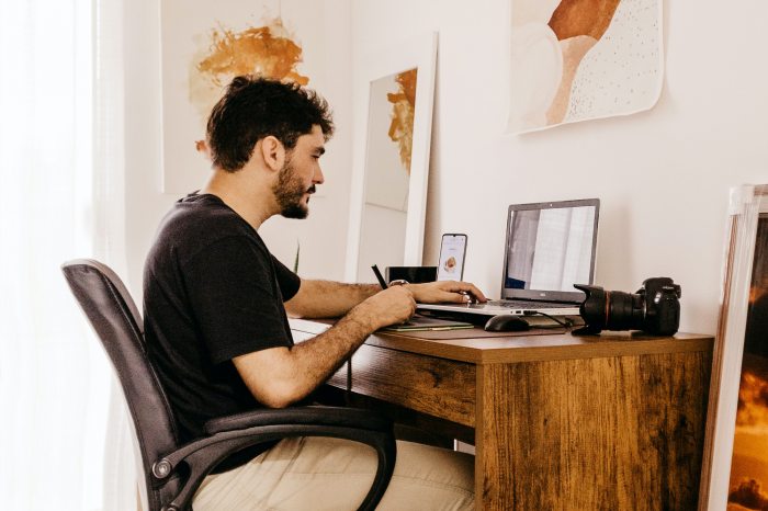 Egy férfi egy íróasztalnál ül és dolgozik