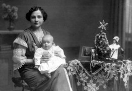 A woman with her child beside a Christmas tree in 1906
