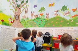 az Ecsetre fel a Gyermekekért által festett fal előtt gyerekek állnak