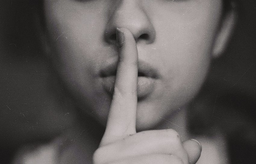 Családi titkot őrző nő, az ujját a szájához teszi