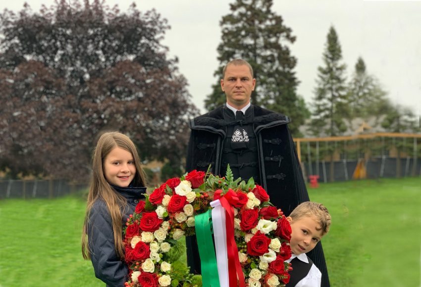 Áron Trufán with his two kids laying a ceremonial wreath in Chicago