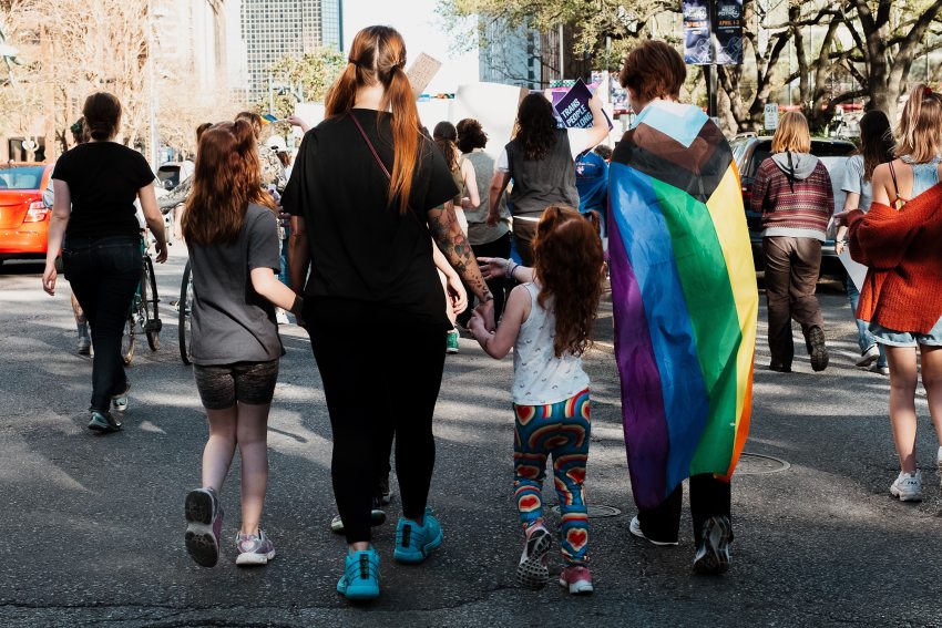 nők gyerekkel és szivárványos zászlóval egy felvonuláson
