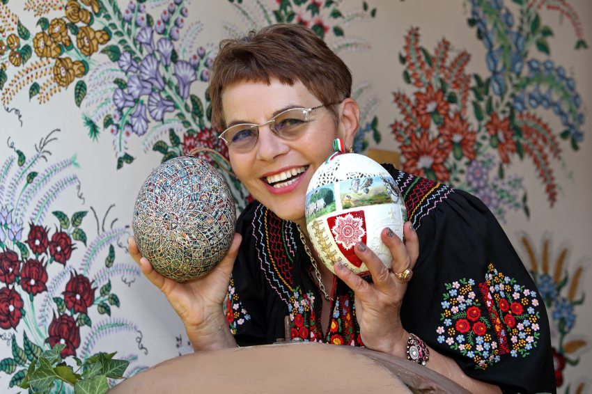 Zsigóné Kati tojásfestő művész, kezében  a Világunk tojása és a Beszélő Tojás