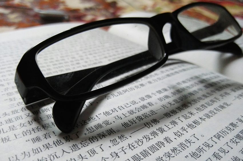 szemüveg kínai betűkkel írt lapon