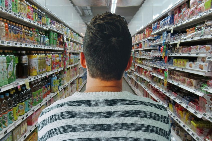 férfi szupermarketben két polc közt