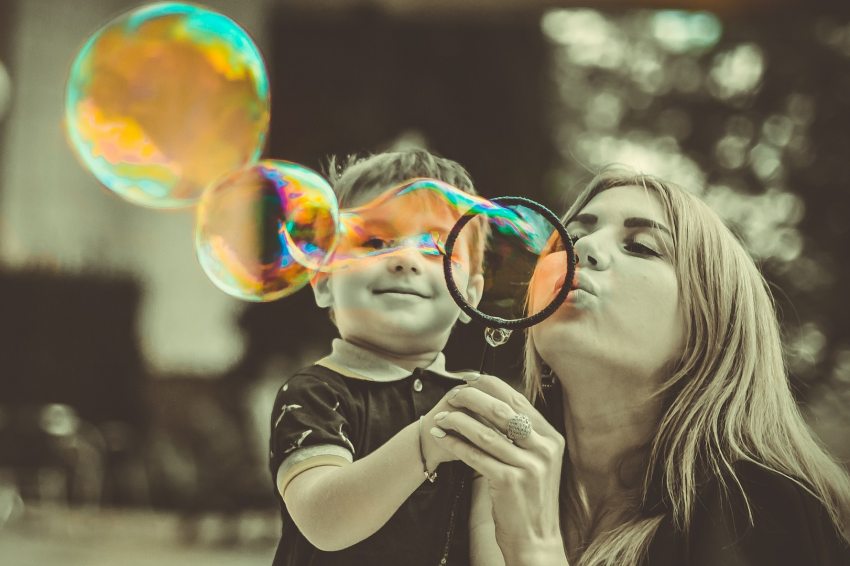 nő kisfiúval színes buborékokat fúj