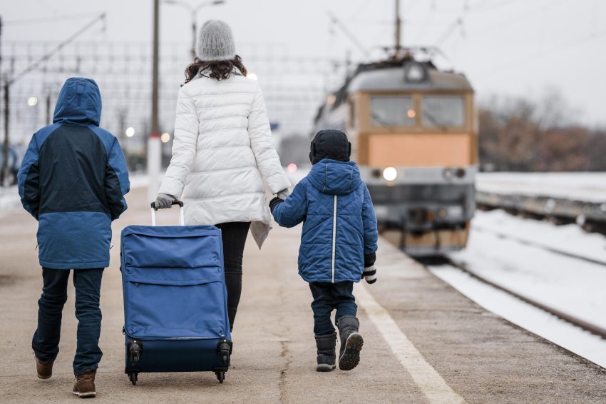 vasútállomáson sétáló nő és két gyerek