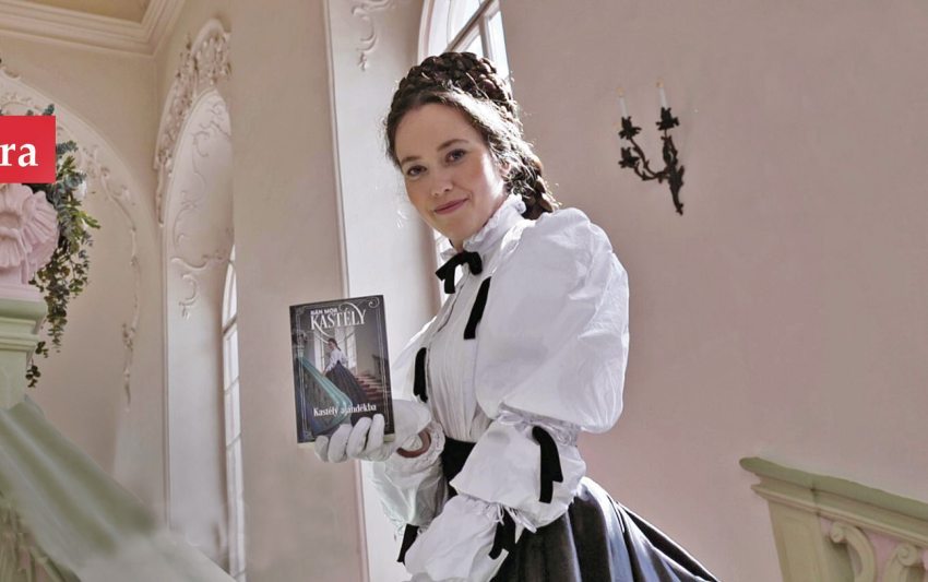 Tímea Dutka, the palace's tourist guide in a costume in the role of Queen Elizabeth – with the novel in her hand