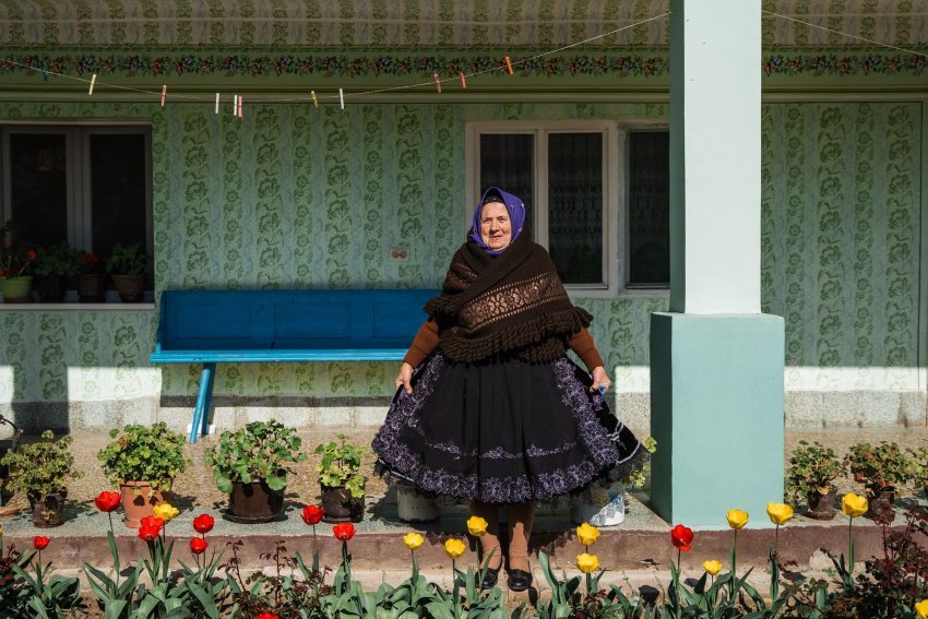 A Swabian woman in front of her house in Vojvodina in traditional Swabian attire