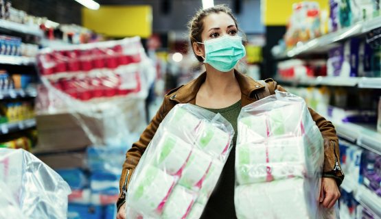 szájmaszkot viselő nő két csomag WC-papírral a kezében