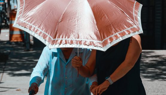 egy idősebb és egy fiatalabb nő esernyő alatt
