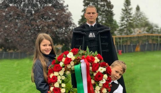 Áron Trufán with his two kids laying a ceremonial wreath in Chicago
