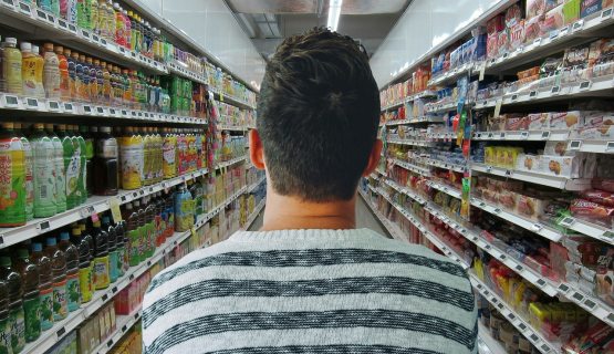férfi szupermarketben két polc közt