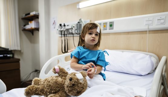 kislány kórházi ágyban, plüssmacival