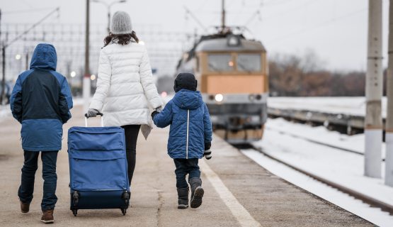 vasútállomáson sétáló nő és két gyerek