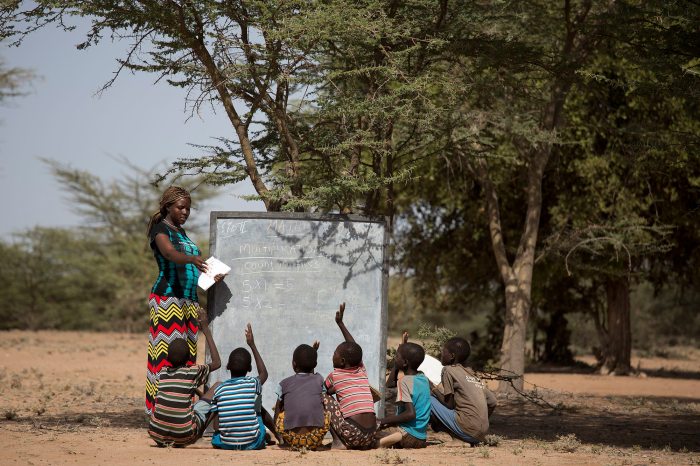Egy afrikai tanár gyerekeket tanít egy fa alatt