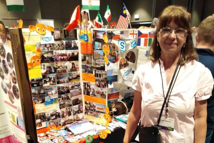 Gyöngyi Tóthné Bán in front of a Hungarian display at an international exhibition