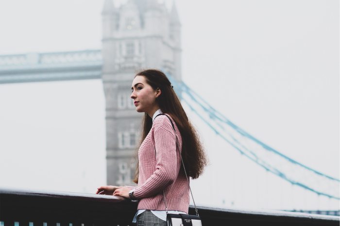 British woman standing in front of Tower Bridge in London