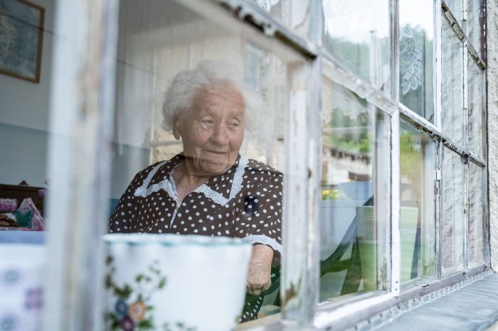 Sári néni behind her window