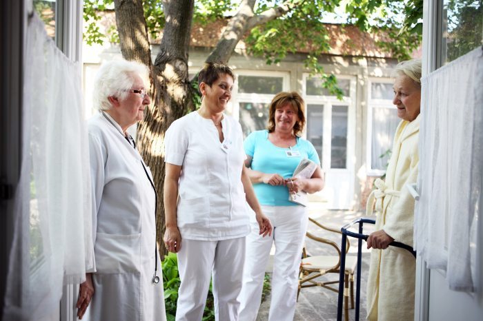Patients and caregivers in a hospice house chatting amiably