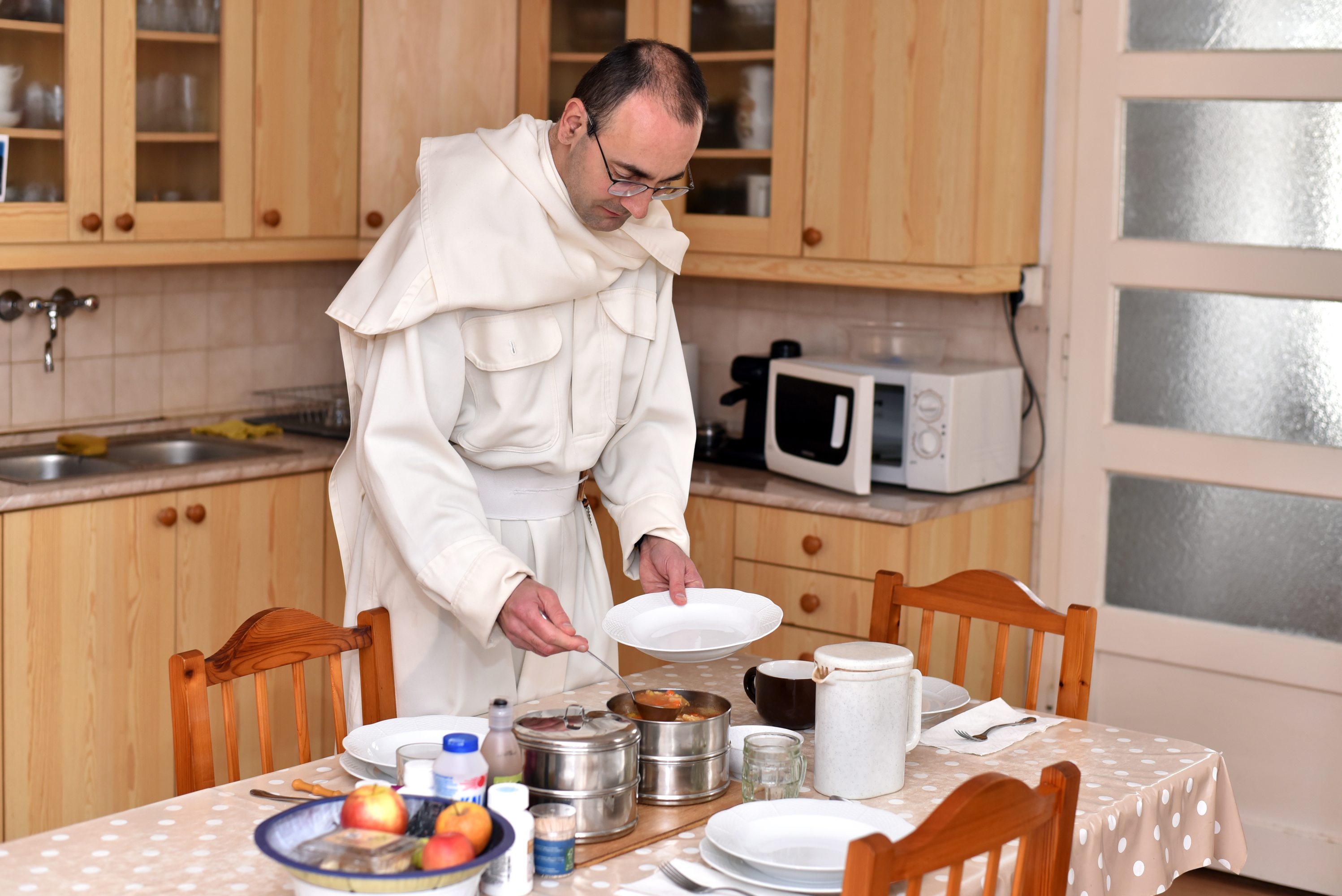 Pauline monk working in a kitchen