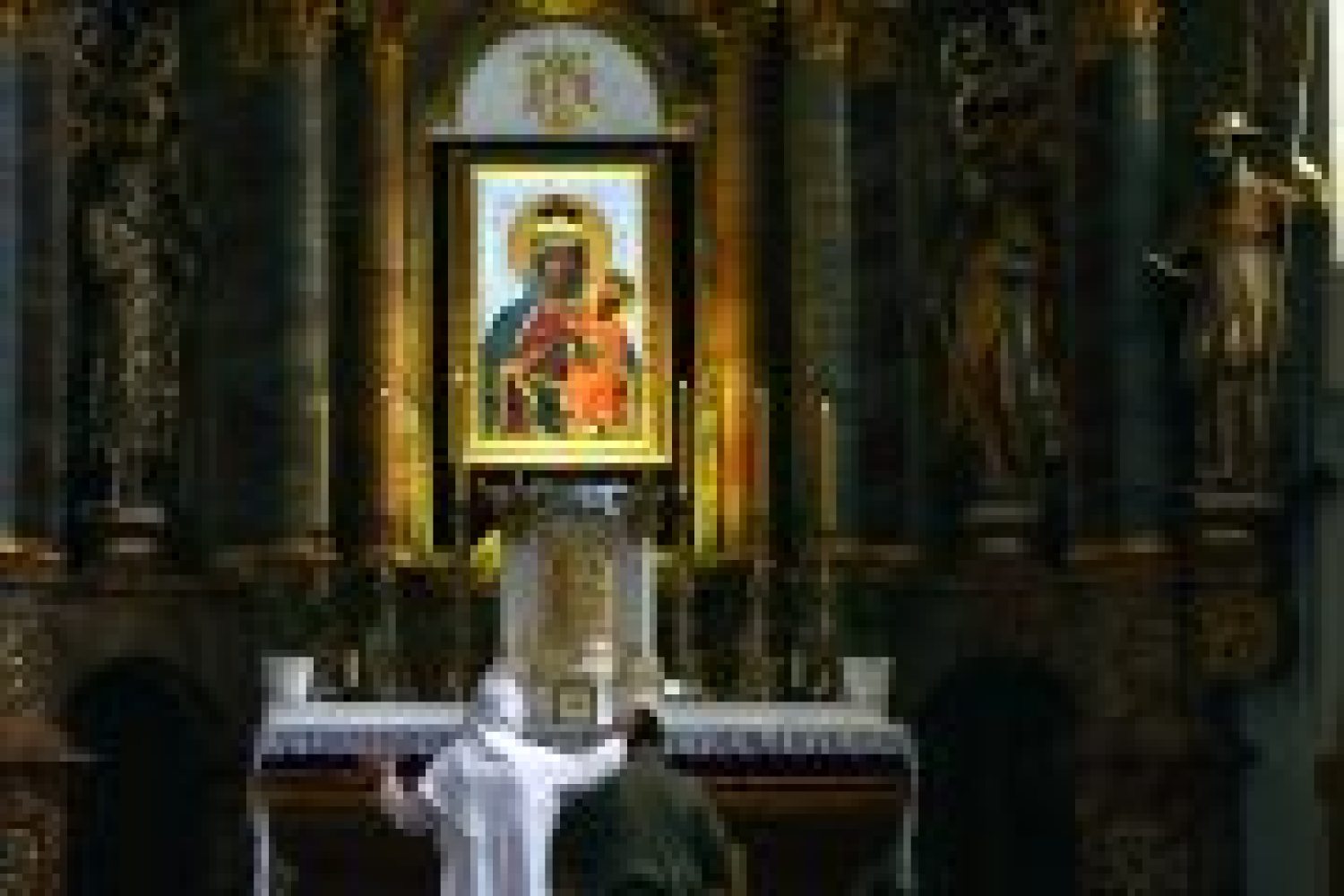 Paulinemonks praying in front of a painting of the Holy Mary