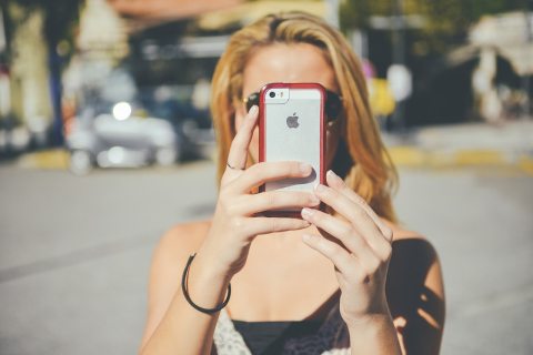 Lány mobiltelefonnal fényképez
