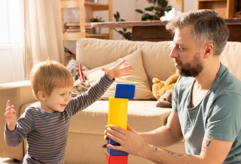 Apa a kisfiával építőkockákkal játszik 