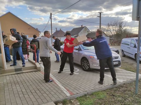 Helyiek és önkéntesek pakolják az adományokat Paposon