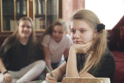 Lány a családi bakancslistán gondolkodik egy tollal a kezében