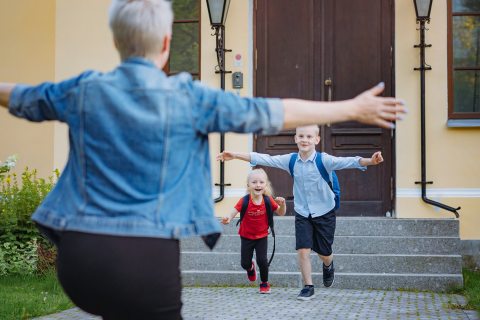 kisfiú és kislány szalad egy széttárt kezű nő felé