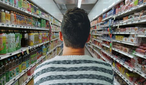 férfi szupermarketben két polc közt