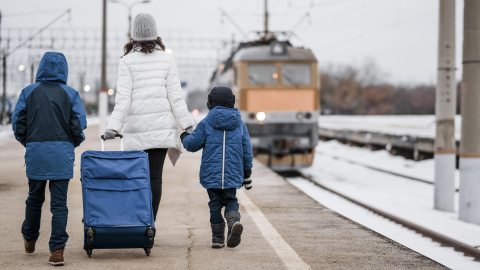 vasútállomáson sétáló nő és két gyerek