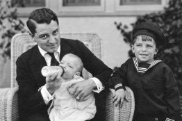 father feeding a baby from a bottle in the 1920s