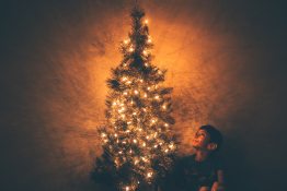 fiú karácsonyfa mellett